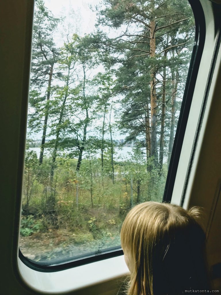 Lapsiperhe käyttää julkisia kulkuneuvoja: Junan ikkunan maisemaa